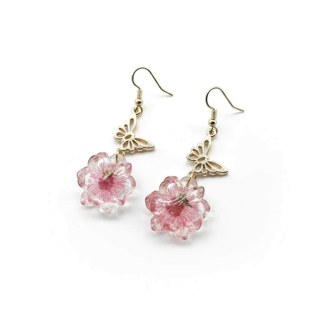 Alyssa's House gold-tone butterfly earrings featuring delicate pink pressed flowers in a resin drop design.