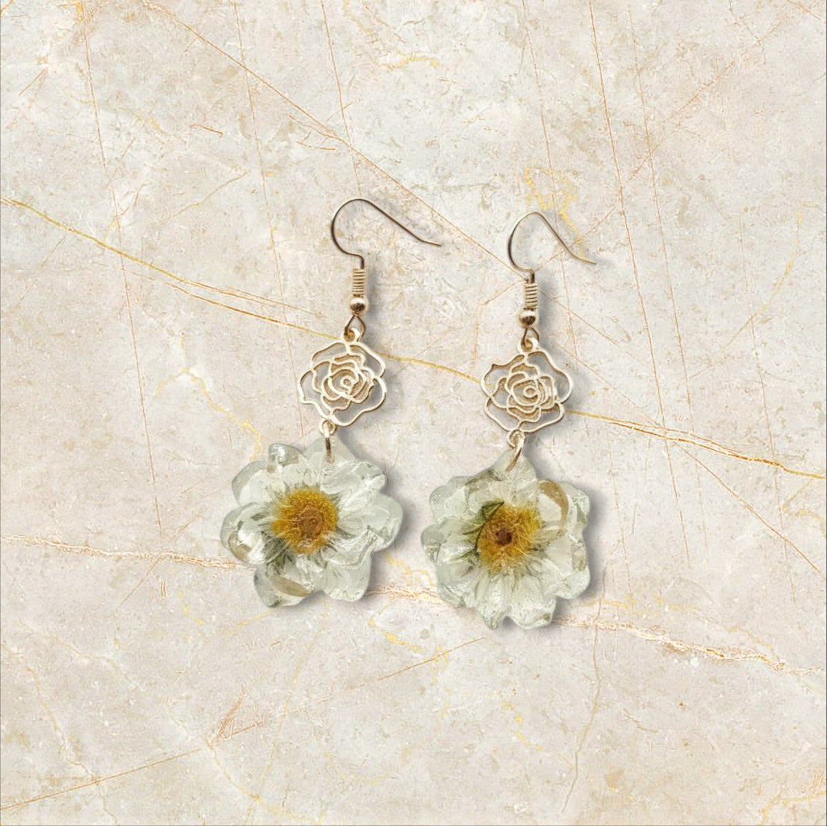 Alyssa's House drop earrings featuring cream pressed flower petals with gold-tone rose charms and hook backings.