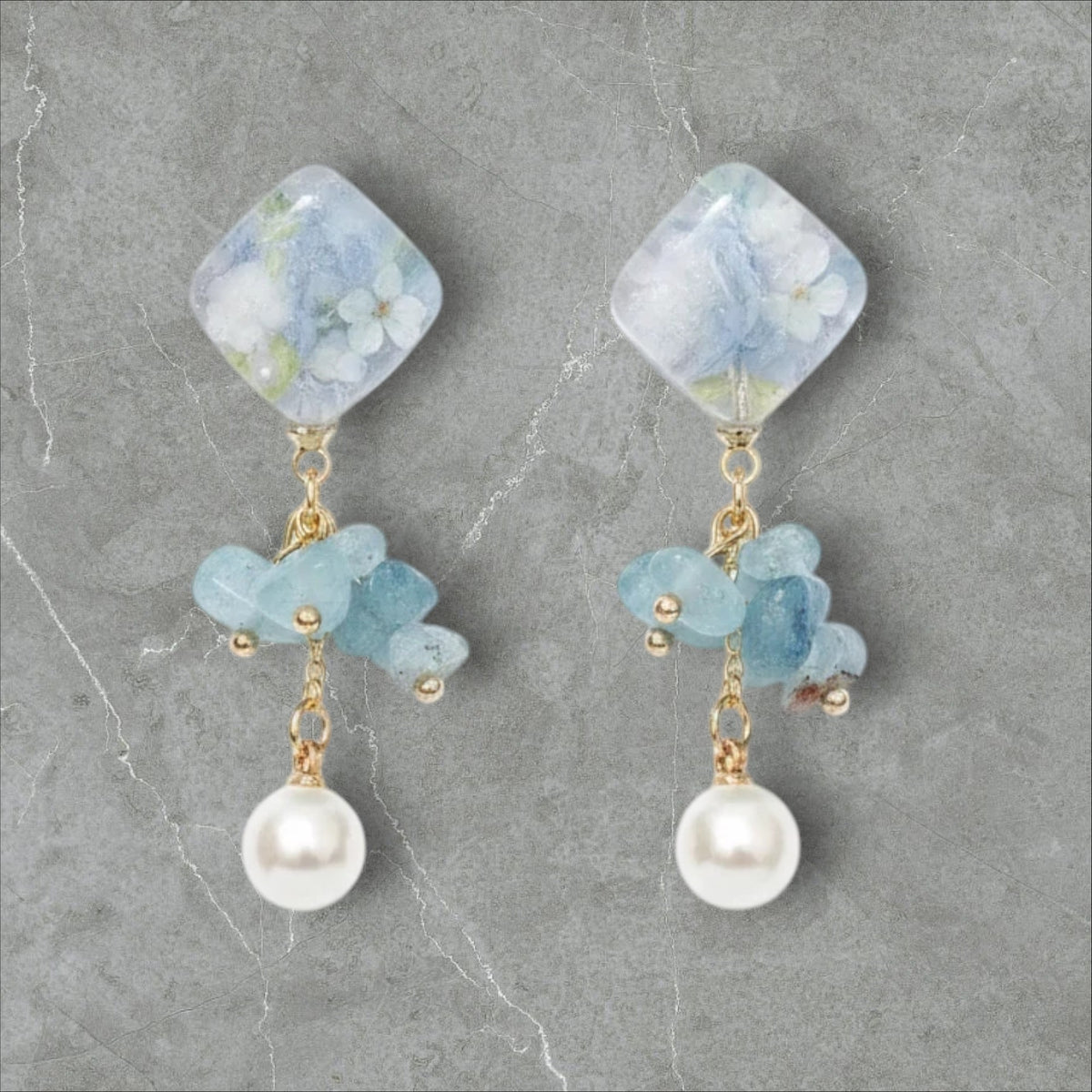 Alyssa's House blue floral square resin drop earrings with stone chips and pearl accents on a white background.