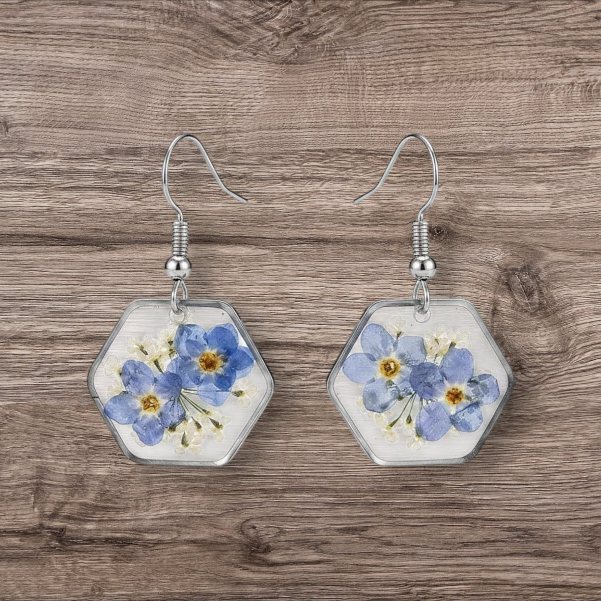Alyssa's House hexagon resin earrings featuring blue forget-me-not flowers encased in silver-tone wire frames.