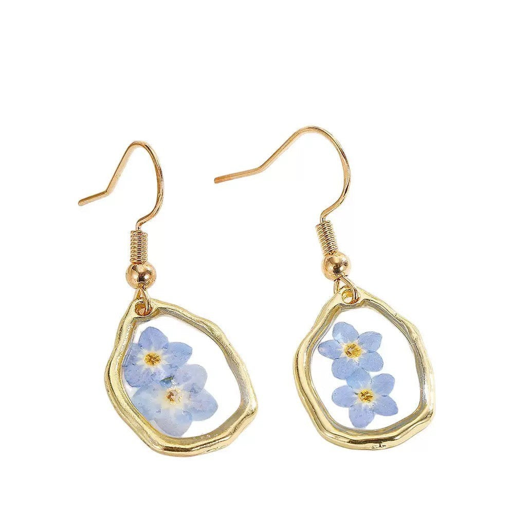 Alyssa's House oval resin earrings featuring blue forget-me-not flowers in a gold-tone frame for everyday wear.