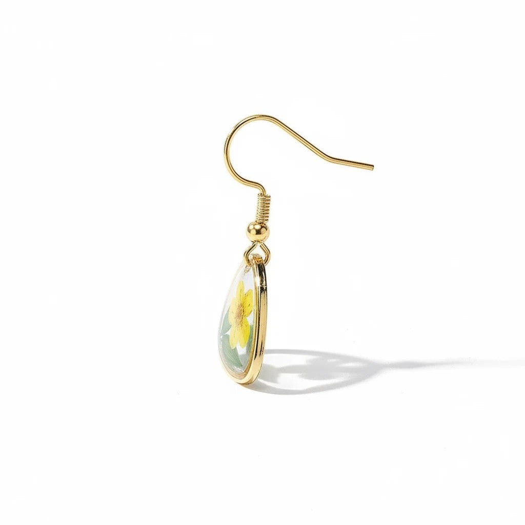 Alyssa's House resin triangle earrings featuring a yellow flower and green leaf encased in gold-tone wire.