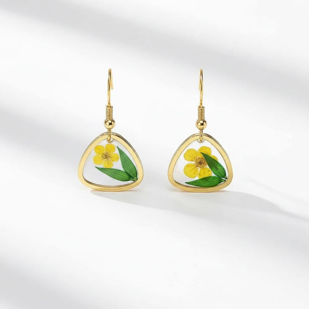 Alyssa's House triangular resin earrings with gold-tone wire, featuring pressed green leaves and yellow flowers.