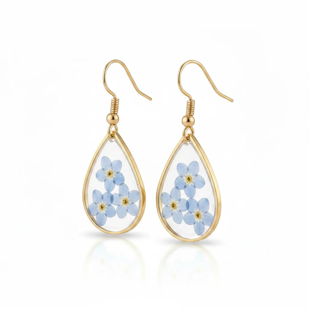 Alyssa's House teardrop resin earrings featuring real blue forget-me-not flowers encased in gold-tone wire frames.