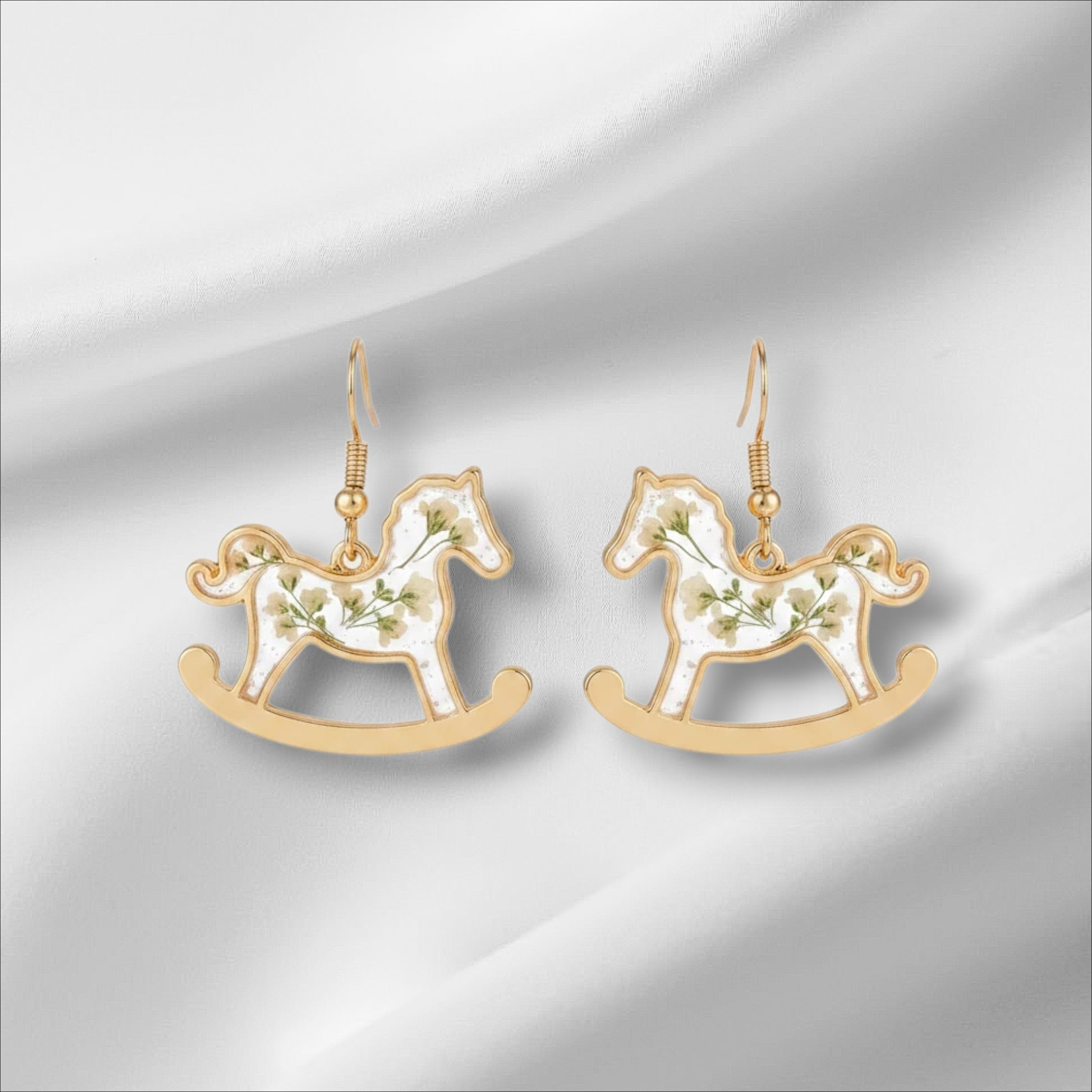 Alyssa's House gold-tone rocking horse earrings featuring clear resin bodies with delicate pressed flowers.