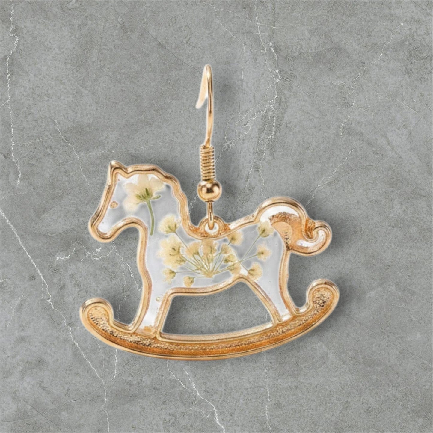 Alyssa's House gold-tone rocking horse earrings featuring clear resin with delicate pressed flowers.